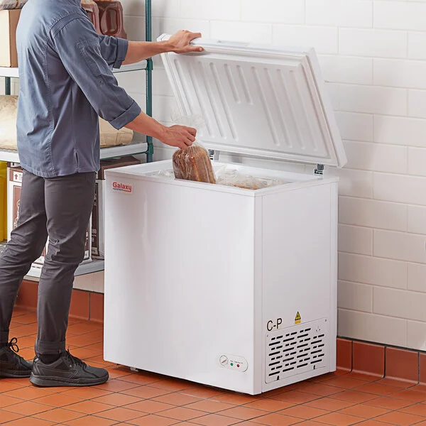 man putting stuff inside chest freezer